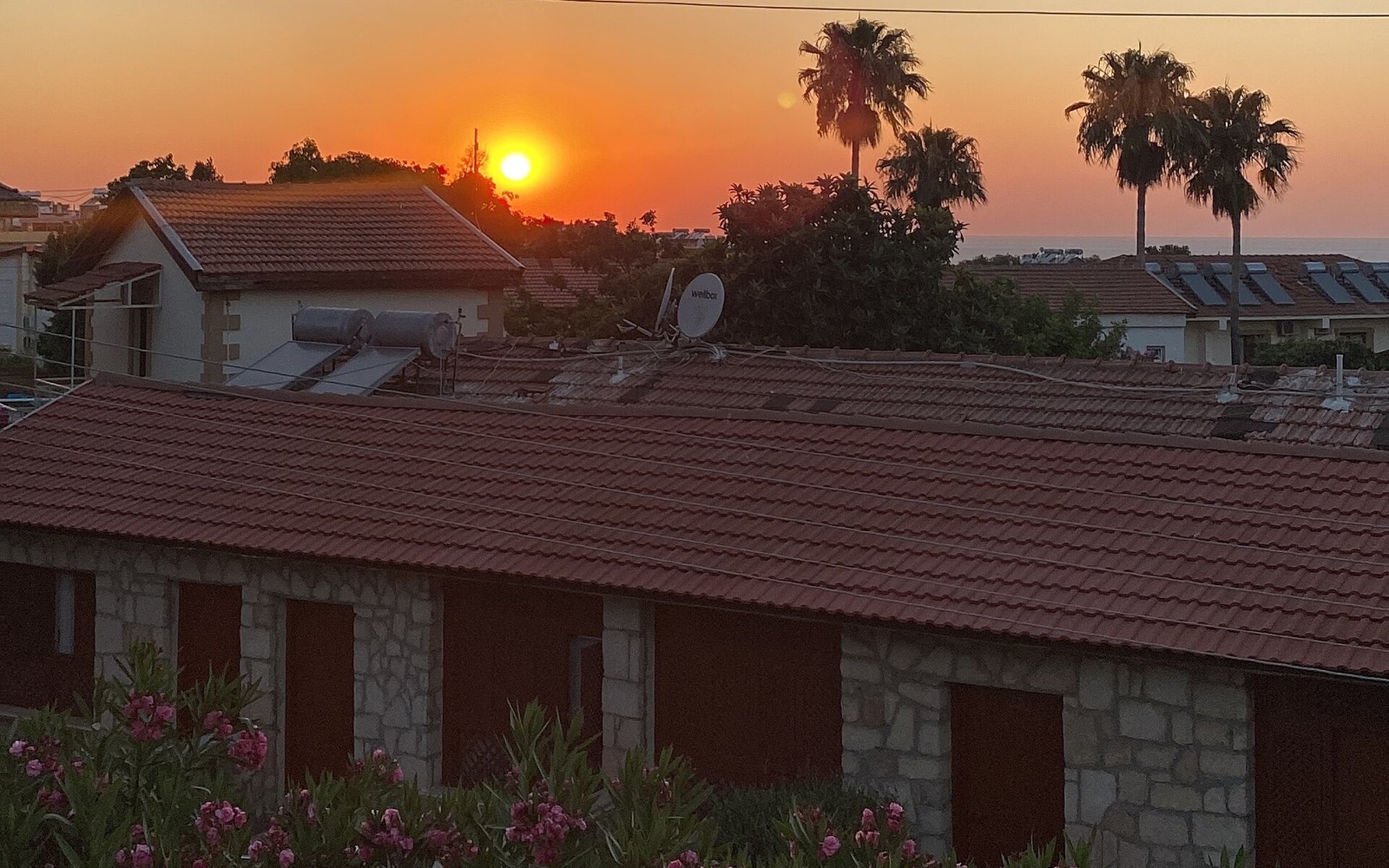 Residential rooftops and the sea at sunset in western Kyrenia